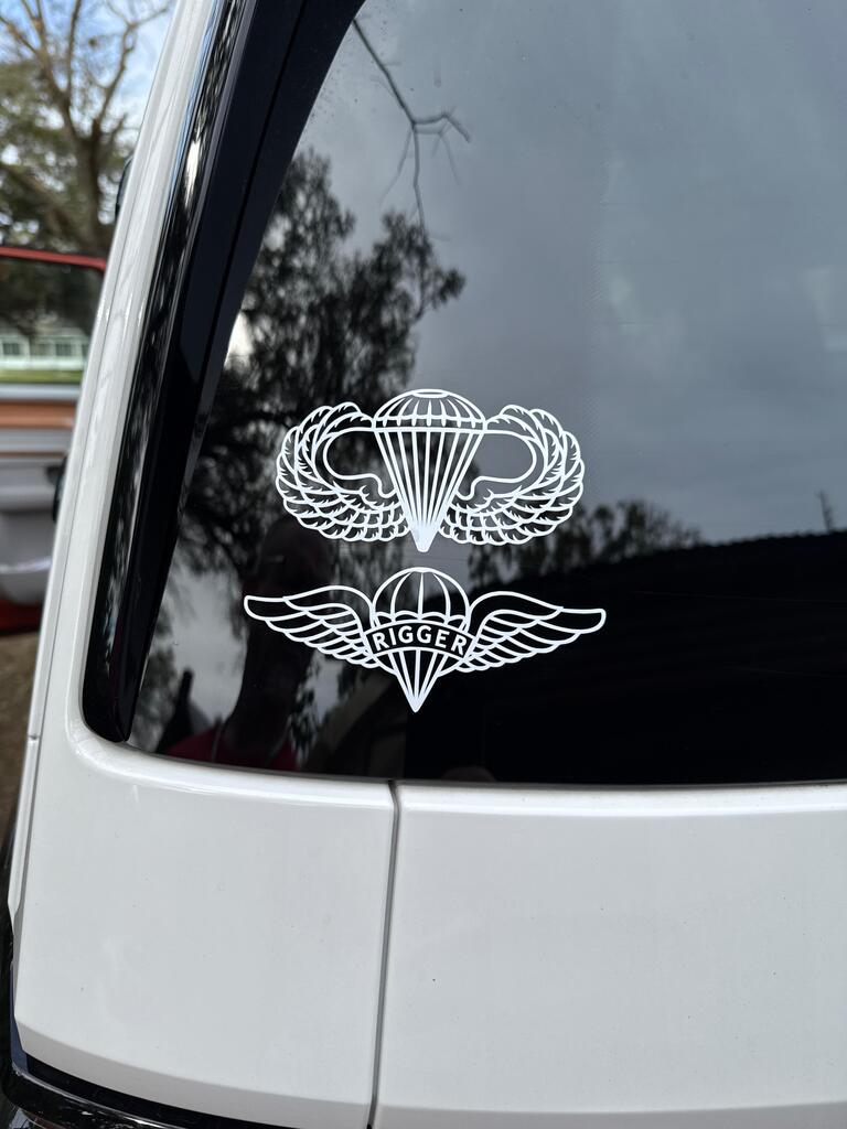 White decal with airborne and Rigger badges on a car window