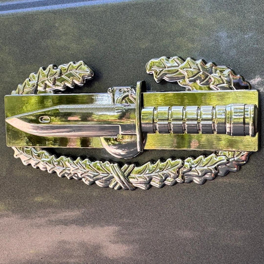 Metallic badge with decorative elements on a dark surface