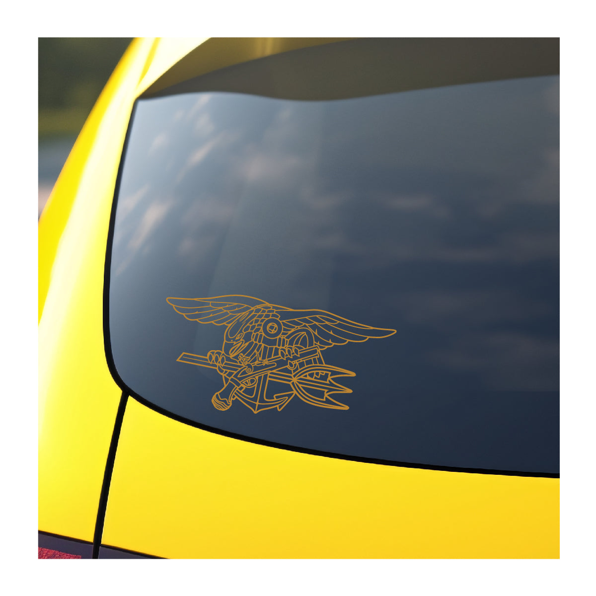 A gold vinyl decal of the Navy SEAL Trident applied on the rear window of a yellow vehicle.