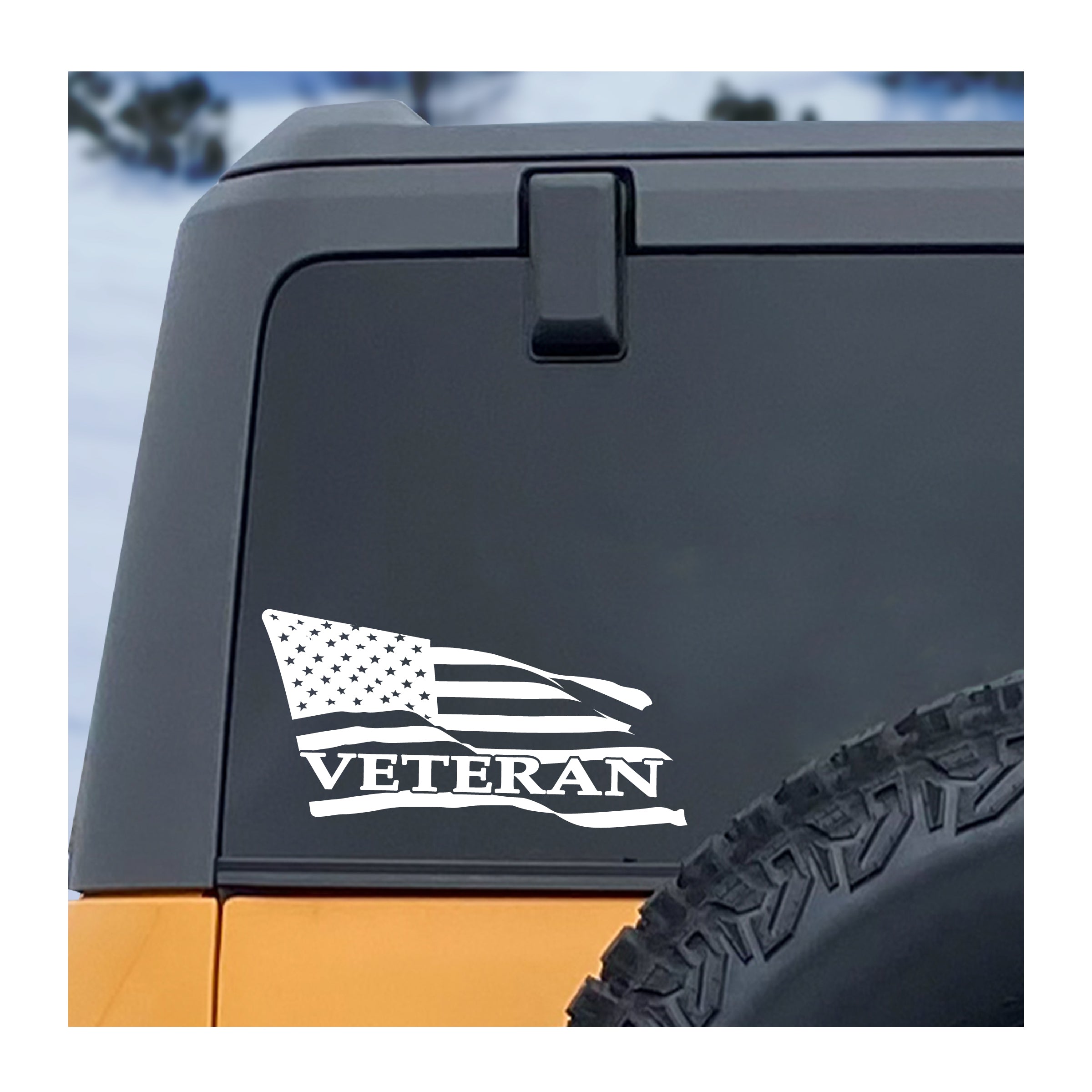 American flag 'Veteran' decal on a vehicle's black tailgate with a snowy background.
