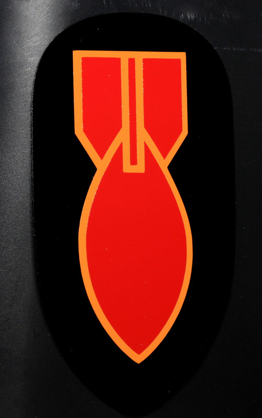 A vinyl decal featuring a red and yellow bomb design with a black tip, indicating it is a World War II era bomb disposal patch.
